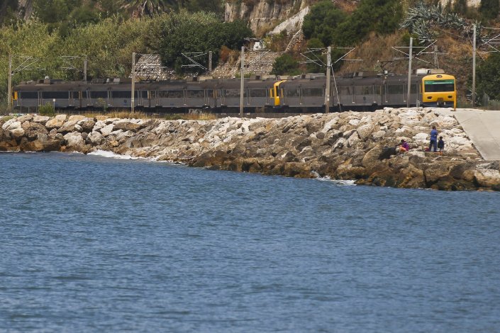 Um comboio da CP percorre a linha de Cascais antes de chegar à estação da Cruz Quebrada, em Oeiras. 23 de Junho de 2014