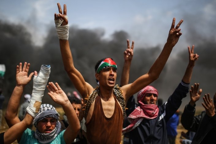 Palestinianos gritam palavras de ordem nos protestos de dia 27 de Abril de 2018, junto à fronteira entre Gaza e Israel.
