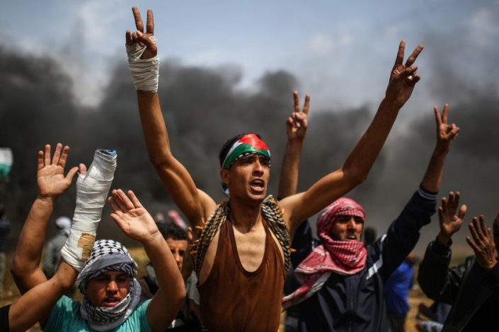 Palestinianos gritam palavras de ordem nos protestos de dia 27 de Abril de 2018, junto à fronteira entre Gaza e Israel.
