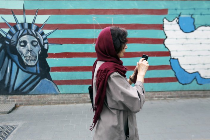 Uma mulher passa junto a um mural na antiga embaixada dos EUA em Teerão, Irão. 8 de Maio de 2018