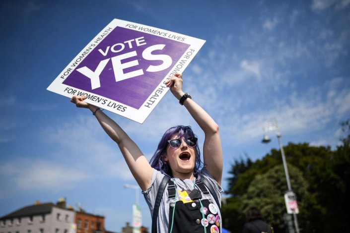 Em dia da votação em referendo sobre a despenalização involuntária da gravidez na Irlanda, uma mulher segura um cartaz pelo sim. 25 de Maio de 2018, Dublin, Irlanda.