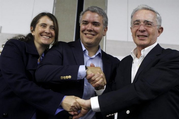 Iván Duque (ao centro) é o novo presidente da Colômbia; em Dezembro último, foi apresentado por Álvaro Uribe como o seu candidato à presidência 