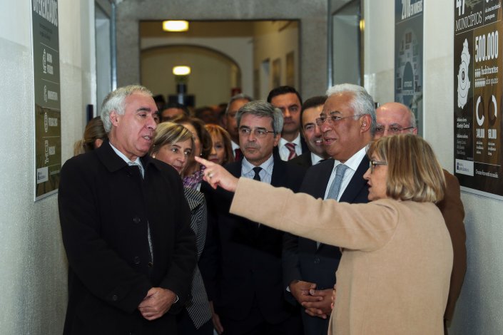 O presidente da Câmara Municipal de Évora (esquerda) e o primeiro-ministro ouvem explicações da presidente do conselho de administração do Hospital de Évora