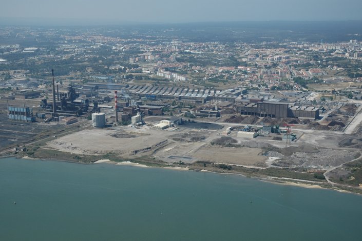 Imagem aérea da Siderurgia Nacional, com a Aldeia de Paio Pires por detrás