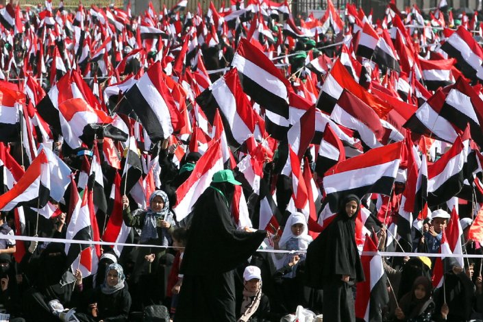Mulheres iemenitas acenam bandeiras durante um comício de denúncia do quarto aniversário da campanha militar liderada pela Arábia Saudita (aliado dos EUA na região) no Iémen, em Sanaa, Iémen, 26 de Março de 2019. A agressão saudita já provocou mais de 15.000 mortos.