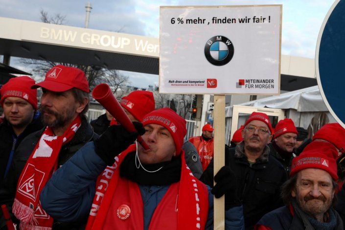 Trabalhadores da BMW em greve mostram um cartaz em que expressam a exigência de um aumento salarial de 6% (2 de Fevereiro de 2018)