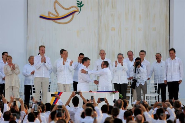 O líder das FARC-EP, Timoleón Jiménez, e o presidente da Colômbia, Juan Manuel Santos, cumprimentam-se no decorrer da cerimónia protocolar de assinatura do Acordo Final de Paz em Cartagena das Índias