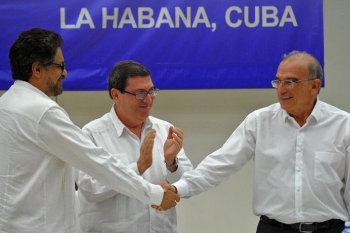 Iván Márquez (esq.) e Humberto de la Calle (dir.) cumprimentam-se após a assinatura do acordo de paz em Havana