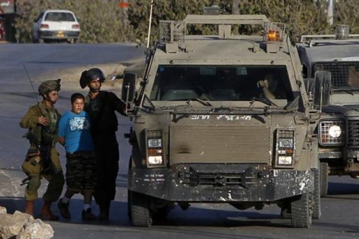 Uma criança palestiniana é presa por soldados israelitas na aldeia de Salwad, a leste de Ramallah (Margem Ocidental ocupada)