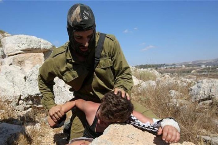 Um soldado israelita tenta prender um rapaz palestiniano num protesto perto de Ramallah, na Margem Ocidental